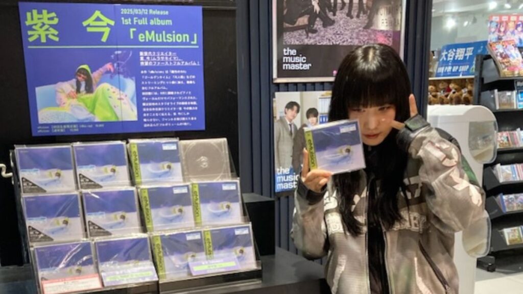 アルバムを持ってポーズをとる紫今